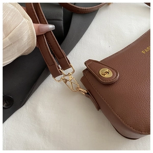 Detail of brown litchi pattern leather with gold twist lock and FASHION logo