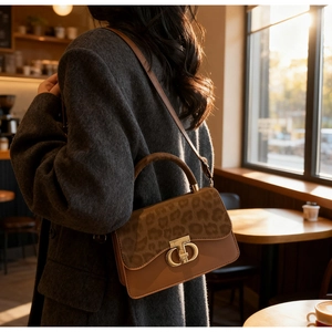 Fashionable leopard print and brown leather shoulder bag shown in an urban street setting