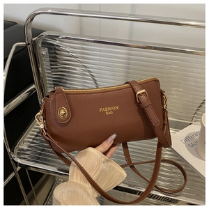 Close-up of brown pebbled leather bag with gold Fashion Bag logo and metallic hardware