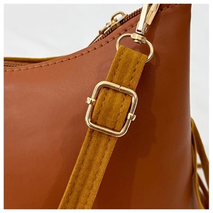 Detail view of adjustable strap with gold-tone hardware and fine stitching on a brown tote