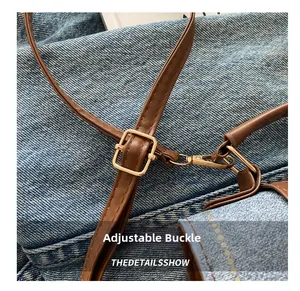 Detail of adjustable golden metal buckle on premium denim shoulder bag strap