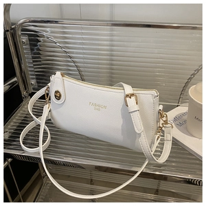 Detail of white lychee-texture PU leather shoulder bag with gold hardware and logo