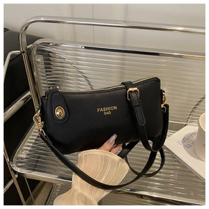 Close-up of black lychee grain leather handbag with gold zipper and fashion bag logo