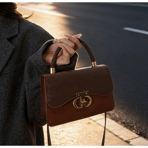 Detail of a brown leopard patchwork handbag with a golden clasp and matte texture