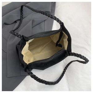 Top view of black tote bag interior showing beige lining and woven handle details
