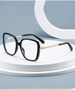 Detail of square black PC frames with gold metal temples on a minimalist display stand