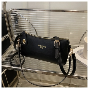 Close-up of black lychee grain leather handbag with gold metal hardware and fashion text