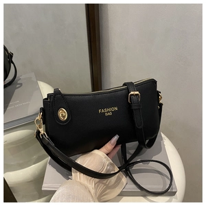 Close-up of black crescent bag with pebble texture, gold hardware and fashion logo