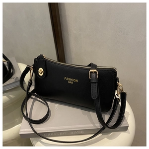 Detail of black pebbled leather texture with golden zipper and Fashion Bag lettering