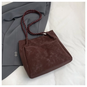 Detail of woven handles on a vintage dark brown tote bag with suede texture for work