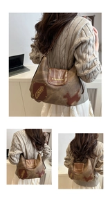 Dettaglio borsa tote vintage marrone con applicazione a cane e tracolla in pelle