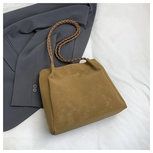 Details der gelben Shopper-Tasche mit geflochtenen Trägern und mattem Leder-Finish