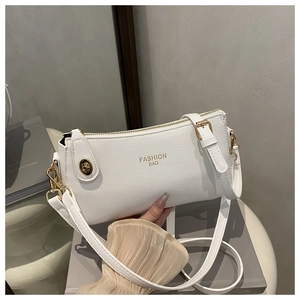 Detail of white lychee pattern PU leather bag with golden Fashion Bag text and hardware