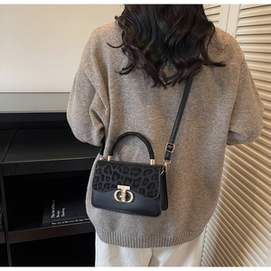 Leopard print crossbody bag styled with a gray sweater and white trousers for winter fashion