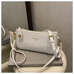 Close-up of white lychee texture leather handbag with golden twist lock and logo detail