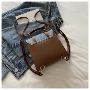Detail of vintage square bag with contrast coffee leather and blue denim patchwork