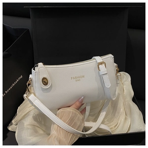 White lychee leather shoulder bag with gold zipper inside a luxury black gift box
