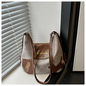 Vista dettagliata della borsa tote in tela grigia con finiture in pelle marrone e logo