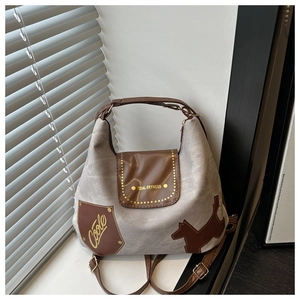 Dettaglio della borsa tote in tela con finiture in pelle marrone e applicazione bassotto
