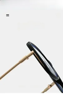 Detail of durable metal hinge connection on stylish black and gold square glasses