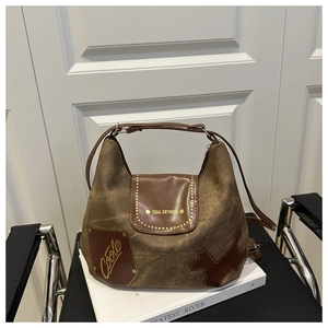 Dettaglio di una borsa tote vintage in tela marrone con patta in pelle e inserti patchwork