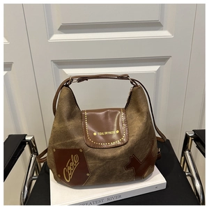 Dettaglio della borsa tote vintage in tela marrone con patch in pelle e scritte metalliche