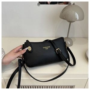 Close-up of the black lychee texture leather bag with a gold metal twist-lock buckle
