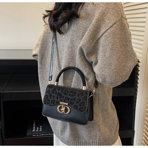 Chic leopard print handbag styled with grey sweater in minimalist home interior