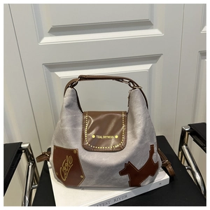 Dettaglio borsa tote in tela grigia con patta in pelle marrone e toppe eleganti