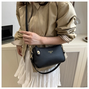 Detail of black pebbled leather texture with gold buckle and Fashion Bag lettering
