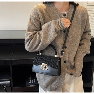 Detail of elegant black leather handbag with leopard print flap and golden ring closure