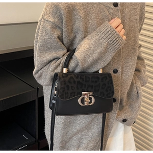 Detail of leopard print flap crossbody bag with a silver metallic twist lock closure