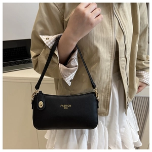 Close-up of black pebble leather crescent bag with gold twist lock and logo detail