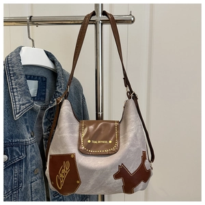 Dettaglio della borsa tote in tela con inserti in pelle marrone e patch a forma di cane