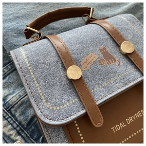 Close-up of retro crossbody bag with cat print and high-quality leather stitching