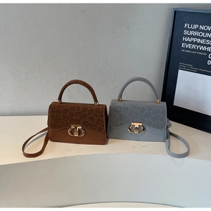 Close-up of leopard print patchwork handbags in brown and grey with gold metal twists