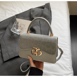 Detail view of leopard print flap bag with gold CD metal clasp and grey leather texture