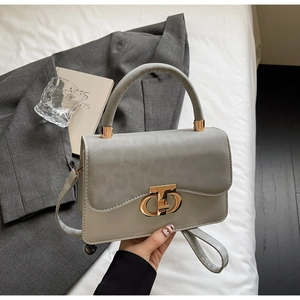 Detail of grey leather handbag with signature gold CD metal lock and crossbody strap