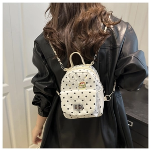 Détail d'un sac à dos à pois avec broderie de burger et fines bretelles en chaîne