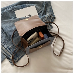 Internal view of color-block crossbody bag showing capacity for phone and cosmetics