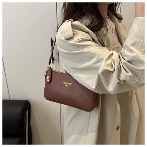 Detailed view of the brown PU leather shoulder bag with gold hardware and embossed text