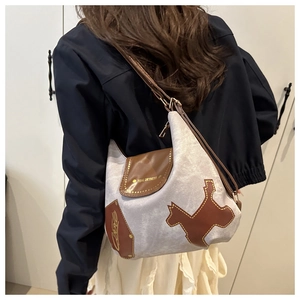 Dettaglio della borsa tote in tessuto grigio e pelle marrone con patch a silhouette di cane