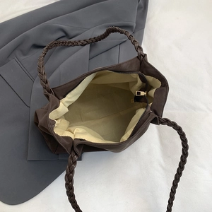 Deep brown minimalist tote bag with woven handles and spacious interior for daily commute