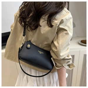 Detail view of black lychee grain crescent crossbody bag shown on model with gold hardware
