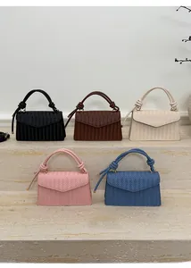 Collection of woven crossbody bags in five stylish colors on minimalist stone steps