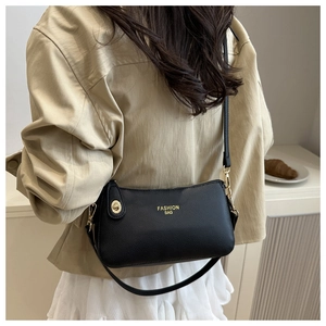 Close-up of black lychee grain leather crossbody bag with gold Fashion Bag lettering