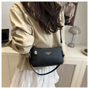 Macro detail of lychee texture black crescent bag with golden clasp and fashion logo