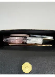 Detail view of the black leather bag interior showing capacity for phone and cosmetics