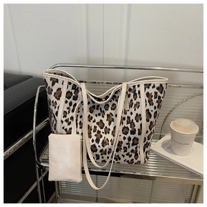 Dettaglio tote leopardata in tela con spalline in pelle beige e portamonete coordinato
