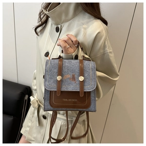 Detail of small grey and brown crossbody bag with cat patch and adjustable straps